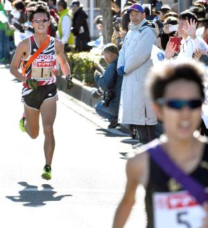 ４区でトップを走るＤｅＮＡの高木登志夫（手前）に迫るトヨタ自動車の服部勇馬（共同）