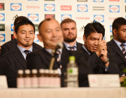 15年10月、ラグビーＷ杯イングランド大会から帰国し、会見で五郎丸（左）のポーズをまねる堀江（右）